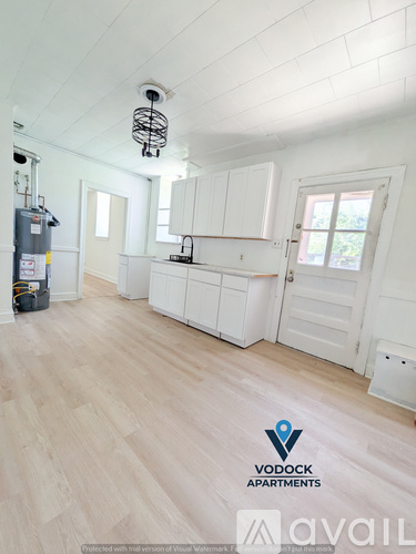 A Vodock Apartments living room with white cabinetry and a wood floor.