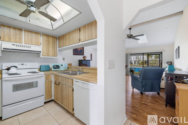 A kitchen with white appliances and wooden cabinets.