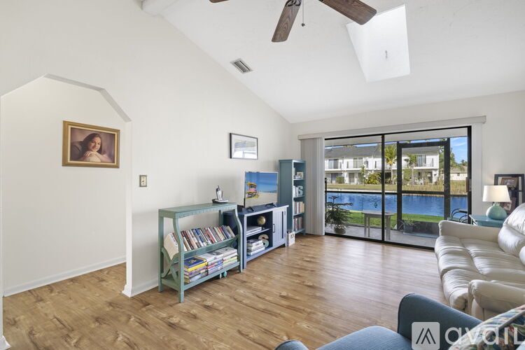 A living room with a ceiling fan and a painting on the wall.
