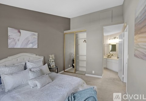 A bedroom with a large bed and a mirrored closet door.