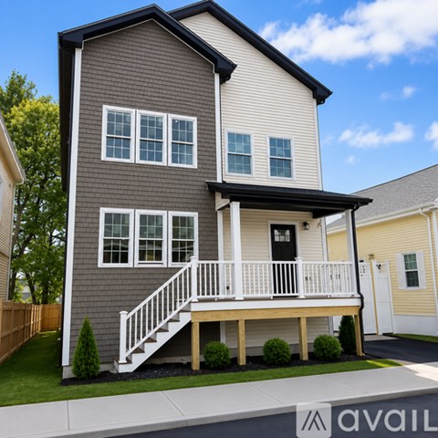A two-story house with a grey and white exterior and a white porch.
