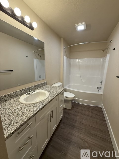 A bathroom with a sink, mirror, and bathtub.