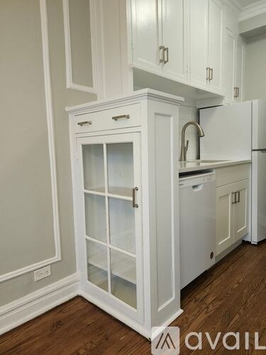 A kitchen with white cabinets and a white fridge.