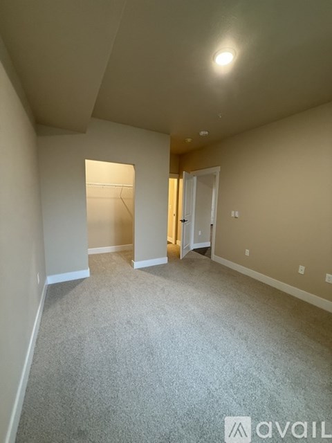 A room with carpeted floor and a doorway leading to another room.