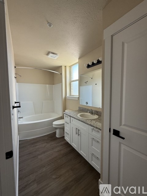 A bathroom with a tub, toilet, and sink.
