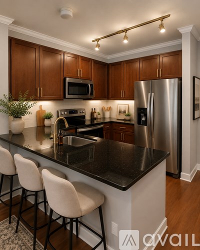 A kitchen with a black counter top and white chairs.