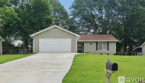 A house with a garage and a mailbox in front.