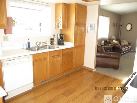A kitchen with wooden cabinets and a white dishwasher.