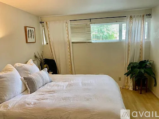 A bedroom with a large bed and a potted plant.