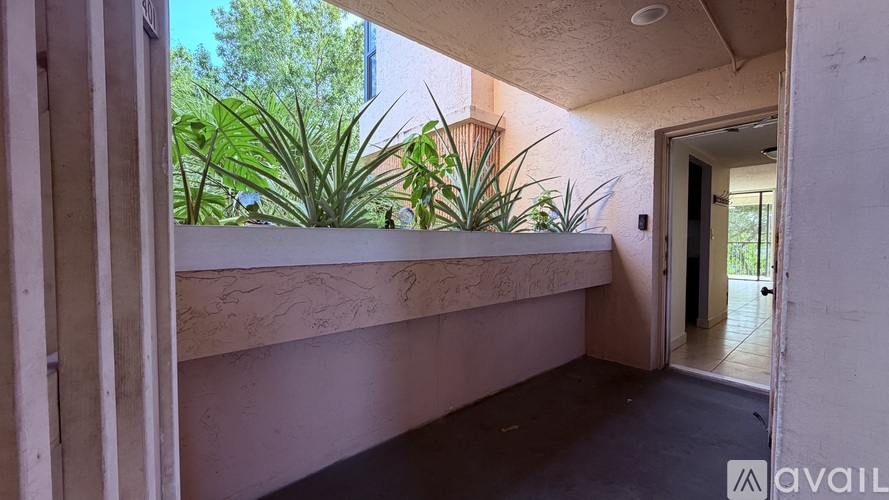 A balcony with a planter box and a doorway.
