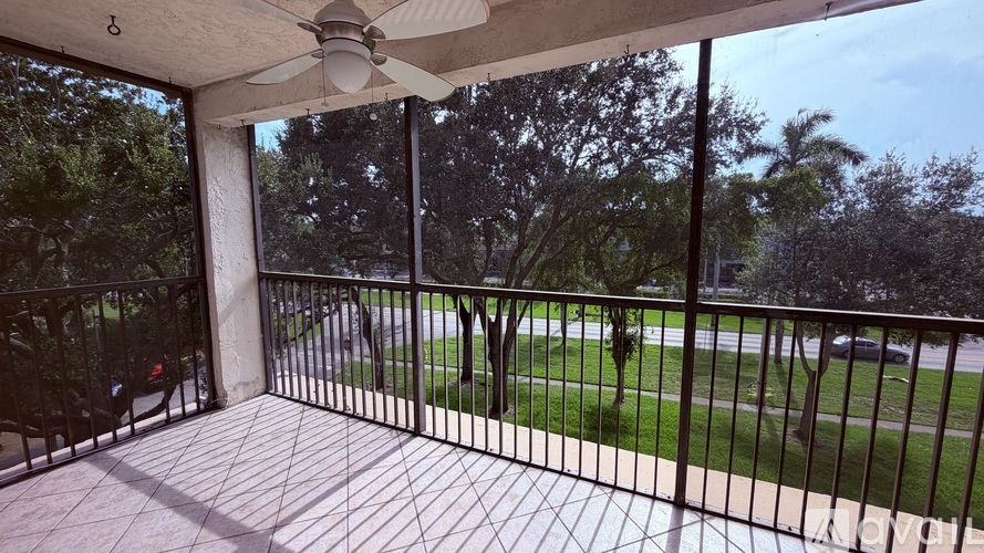 A patio with a fan and a view of a grassy area.