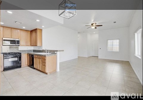 A spacious kitchen with wooden cabinets and a marble countertop.