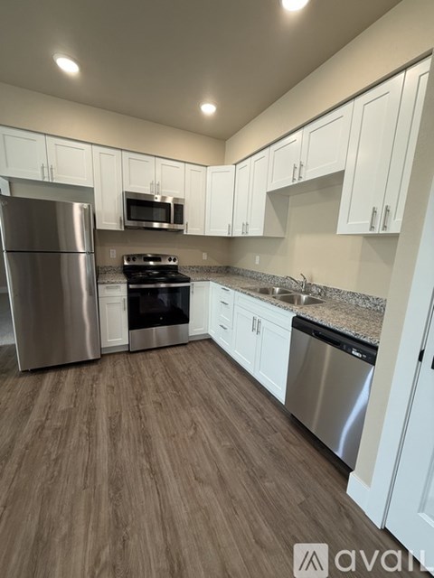 A kitchen with stainless steel appliances and white cabinets.