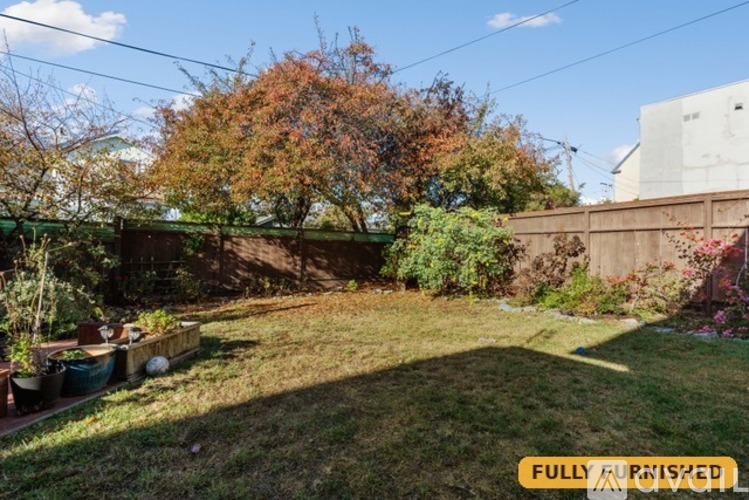 A backyard with a fence and trees.