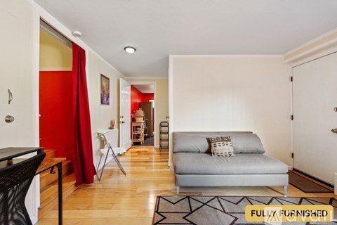 A living room with a grey couch and a black chair.