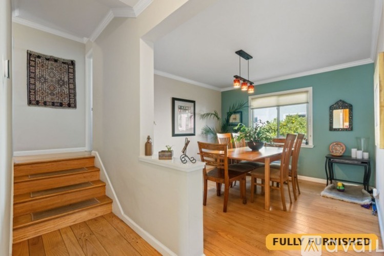 A dining room with a wooden table and chairs.