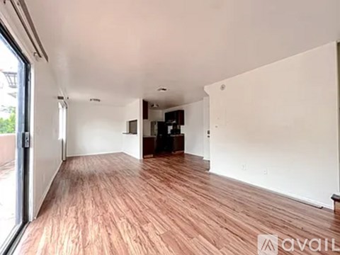 A room with wooden flooring and white walls is available for rent.
