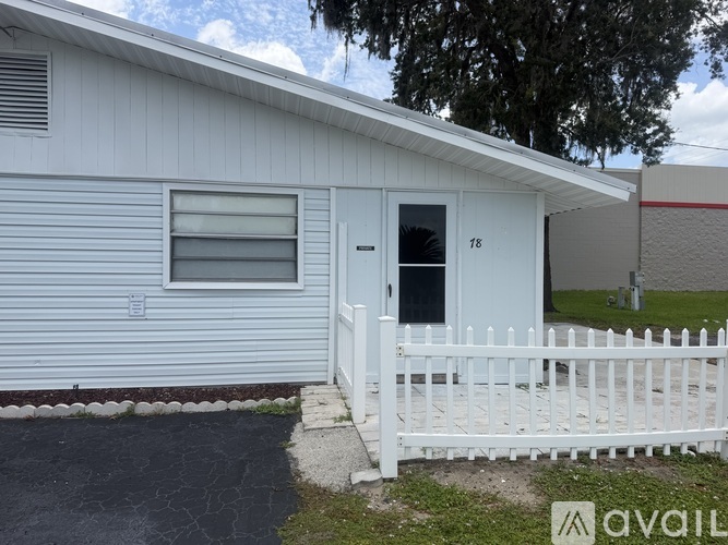 A white mobile home with a black door and window.