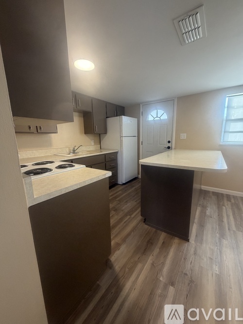 A kitchen with a white stove top oven and a white fridge.