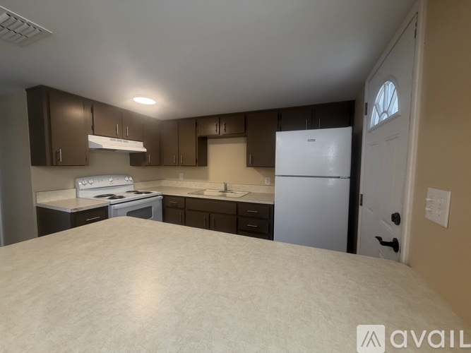 A kitchen with a white countertop and a white refrigerator.