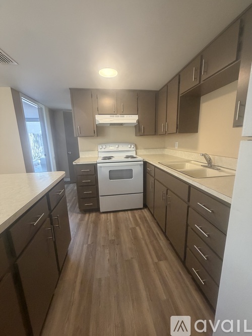A kitchen with wooden floors and a white counter top.