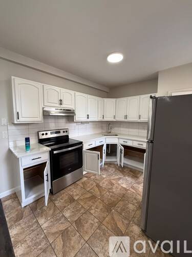 A kitchen with white cabinets and a tiled floor.