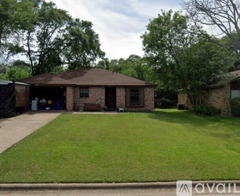 A house with a brown roof and a green lawn in front.