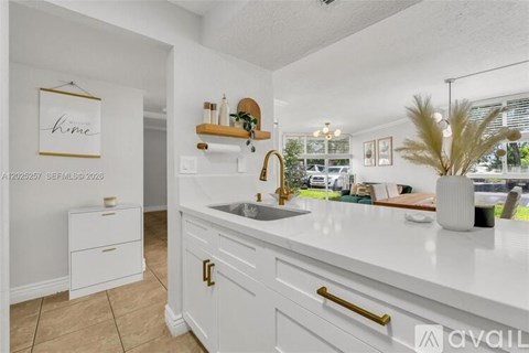 A kitchen with white cabinets and a sink.