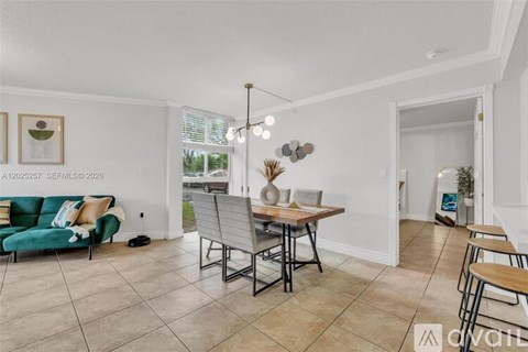 A living room with a green sofa and a dining table with chairs.