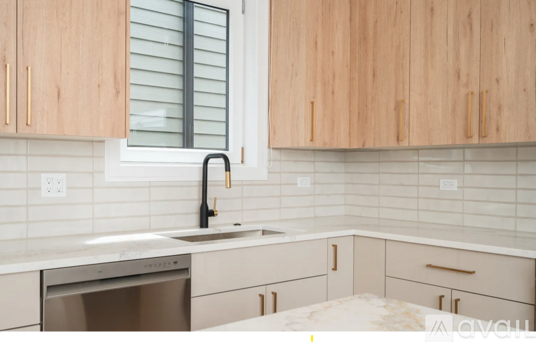 A kitchen with wooden cabinets and a stainless steel dishwasher.