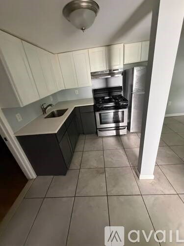 A kitchen with a stove top oven and a sink.