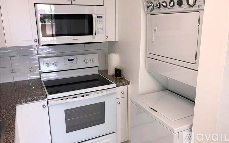 A white kitchen with a stove top oven and microwave.