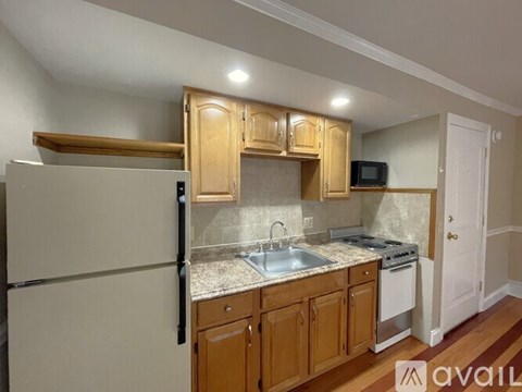 A kitchen with wooden cabinets and a white refrigerator.