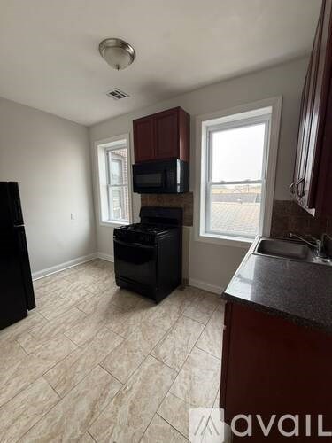 A kitchen with a black fridge, microwave, and dishwasher.