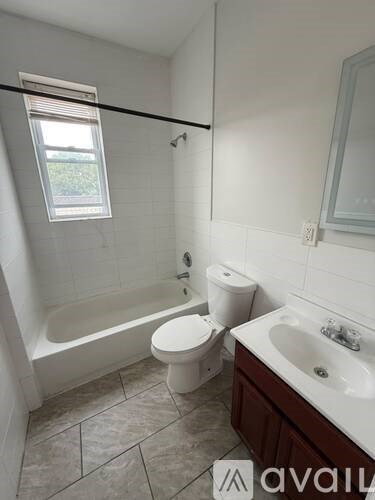 A bathroom with a toilet, sink, and bathtub.