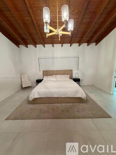 A bedroom with a large bed and a chandelier.