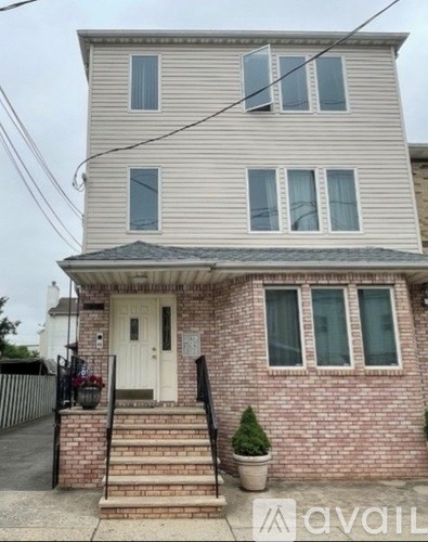 A two-story house with a white door and a brick base.