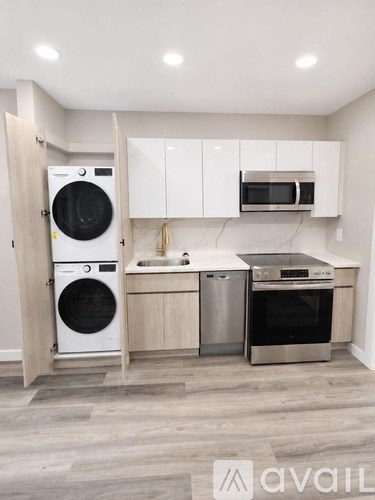 A modern kitchen with a washing machine and oven built into the cabinetry.