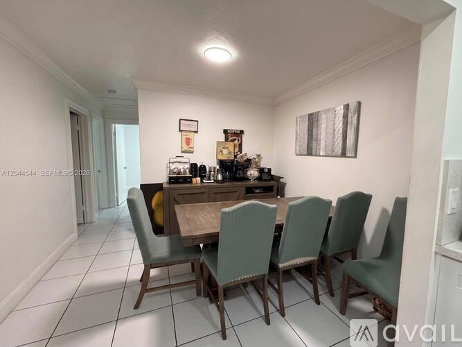 A dining room with a table and chairs.