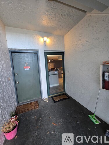A hallway with a door and a fire extinguisher on the wall.