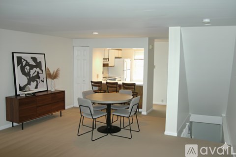A dining room with a wooden table and chairs.