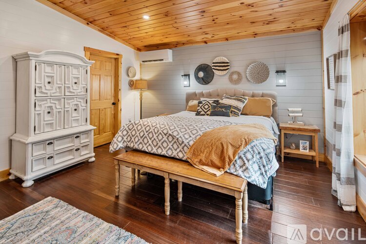 A bedroom with a bed, nightstand, and a wooden bench.