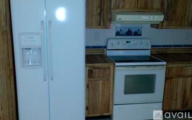 A white refrigerator with a water and ice dispenser on the left side.