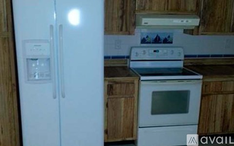 A white refrigerator with a water and ice dispenser on the left side.