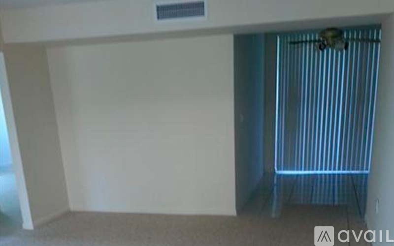 A room with a fan and a window with curtains.