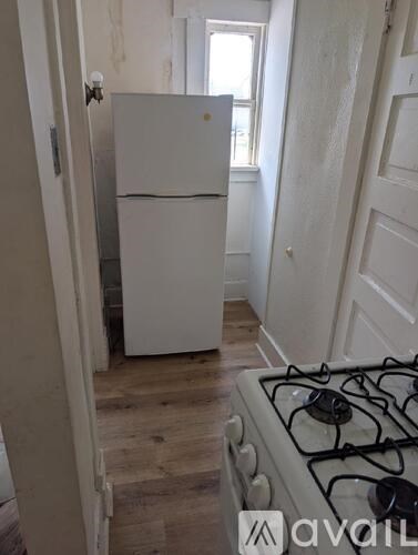 A white fridge in a kitchen with a white gas stove.