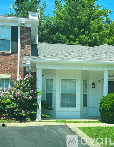 A house with a white front porch and a brick chimney.