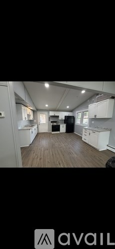 A kitchen with white cabinets and a wooden floor.