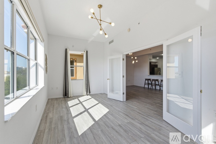 A spacious room with a large window and a view of trees outside.