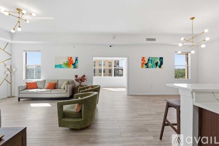 A living room with a white couch and a green armchair.
